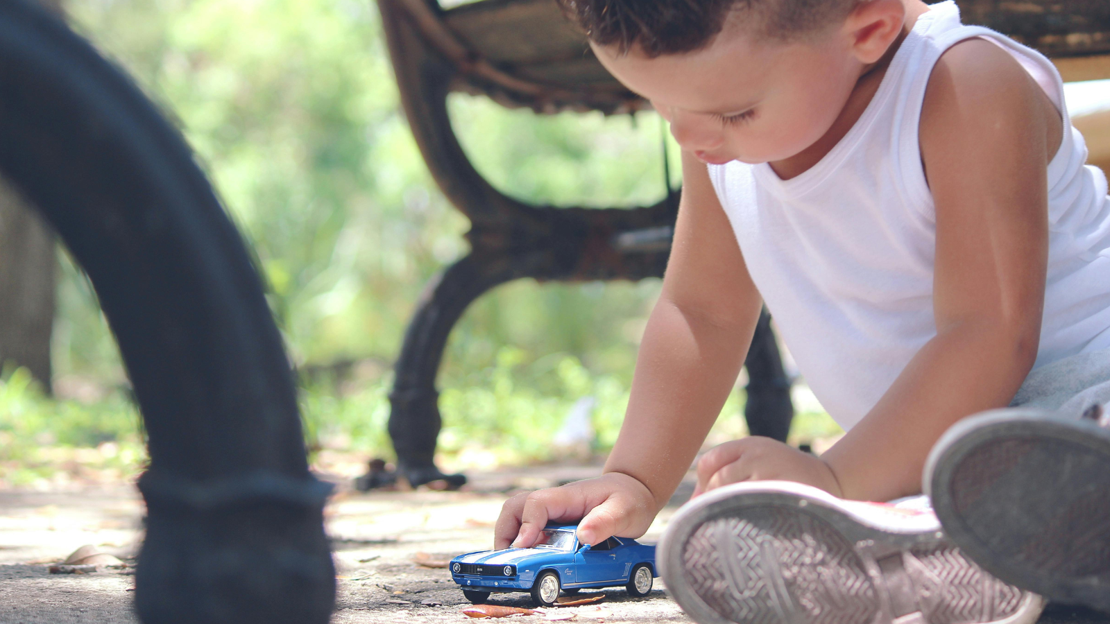 Child playing with toy car in a park